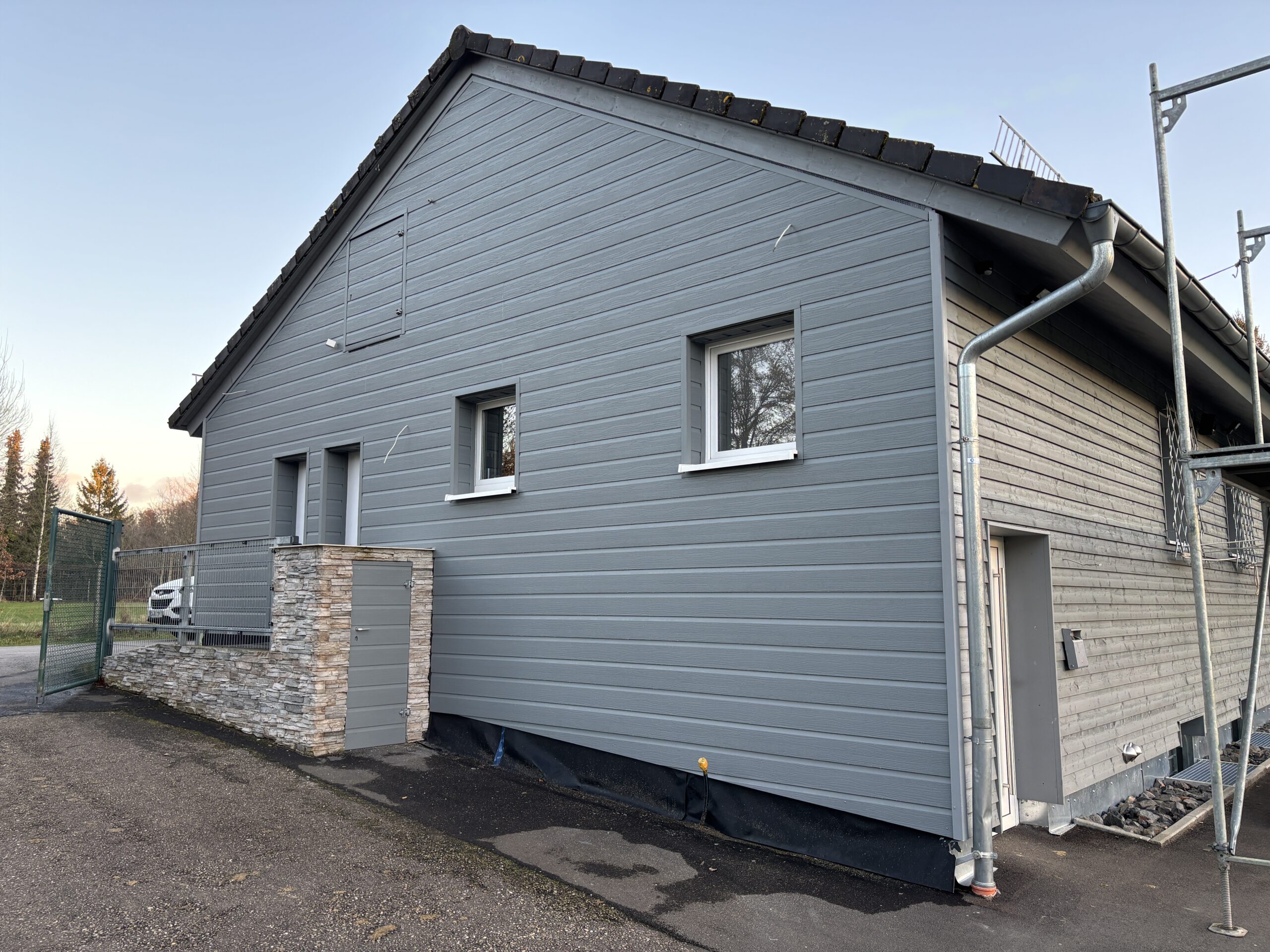 Einstöckiges Haus mit grauer Dielen Verkleidung